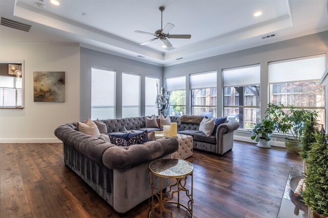 living area featuring a raised ceiling, ceiling fan, ornamental molding, dark wood finished floors, and recessed lighting