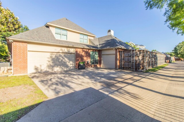 view of front facade with brick siding, a garage, and concrete driveway