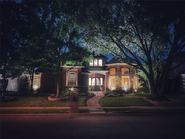 view of front facade with brick siding and fence