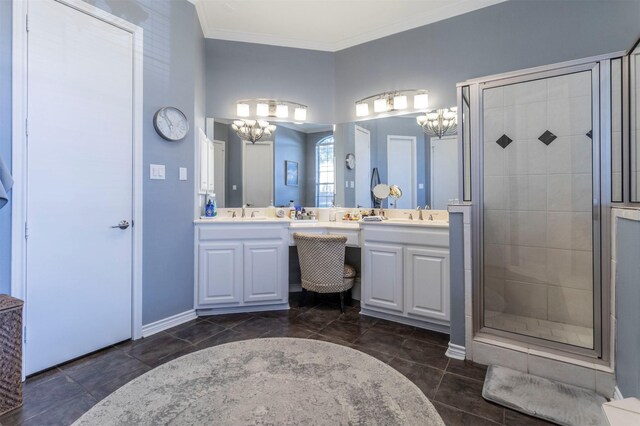 bathroom featuring a chandelier, a shower stall, crown molding, double vanity, and baseboards