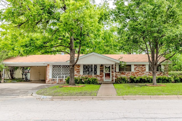 1809 Stevens St, Bridgeport, TX 76426 - ranch-style home with driveway, a front lawn, an attached carport, and brick siding