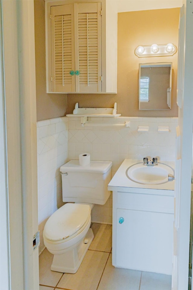 1809 Stevens St, Bridgeport, TX 76426 - half bathroom featuring tile patterned floors, toilet, tile walls, vanity, and wainscoting