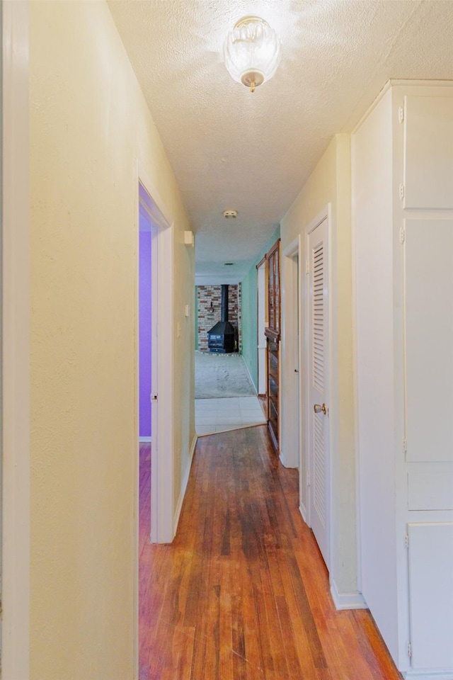 1809 Stevens St, Bridgeport, TX 76426 - hall featuring wood-type flooring, baseboards, and a textured ceiling