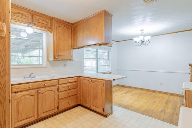 1809 Stevens St, Bridgeport, TX 76426 - kitchen with a sink, light flooring, a peninsula, light countertops, and a chandelier