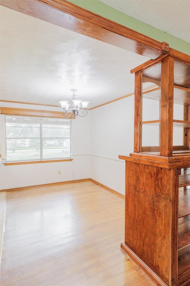 1809 Stevens St, Bridgeport, TX 76426 - spare room featuring a chandelier, light wood-style flooring, and baseboards