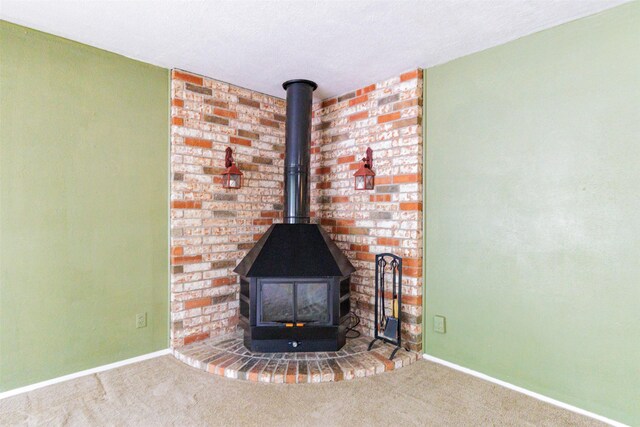1809 Stevens St, Bridgeport, TX 76426 - detailed view of carpet flooring, baseboards, and a wood stove