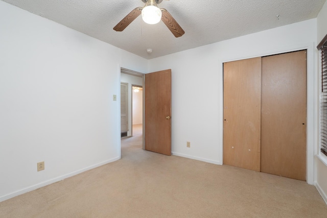 unfurnished bedroom featuring carpet flooring, a closet, baseboards, ceiling fan, and a textured ceiling