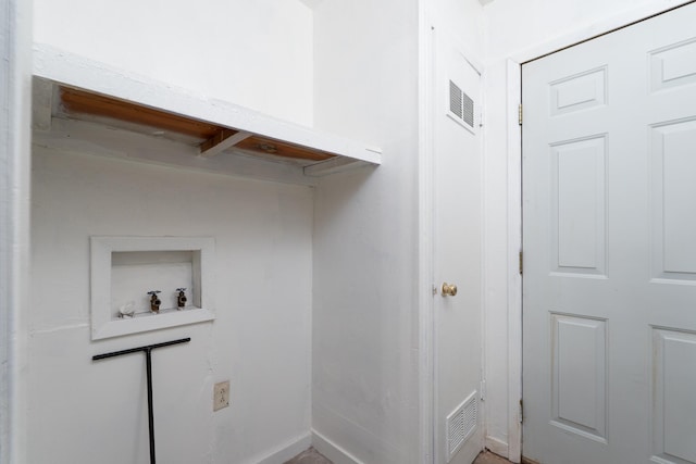 clothes washing area with hookup for a washing machine and baseboards