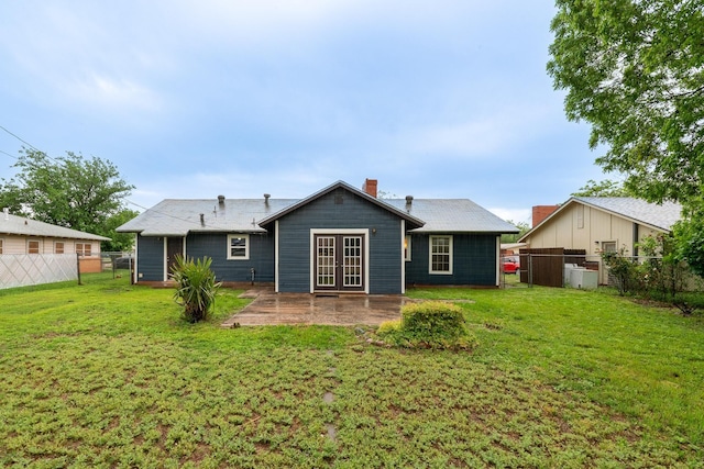 back of house featuring french doors, a chimney, and a gate