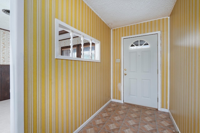 doorway to outside with wallpapered walls, a textured ceiling, baseboards, and crown molding