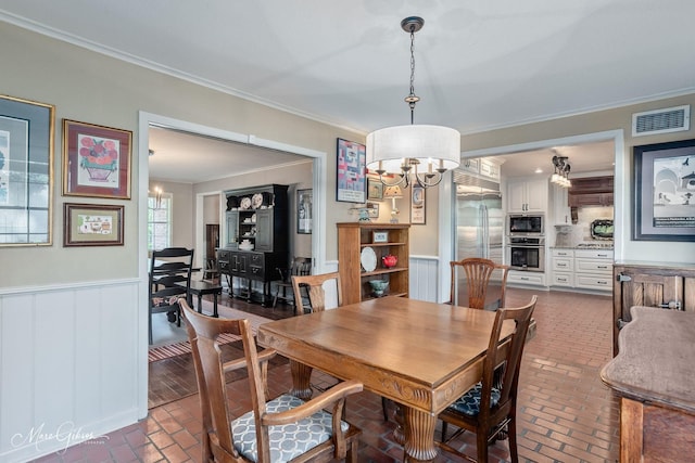6030 Arden St, Shreveport, LA 71106 - dining room with brick flooring, ornamental molding, a wainscoted wall, and a chandelier