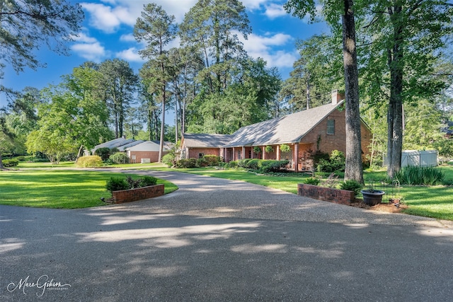 6030 Arden St, Shreveport, LA 71106 - view of front of property featuring a front lawn, a chimney, driveway, and brick siding
