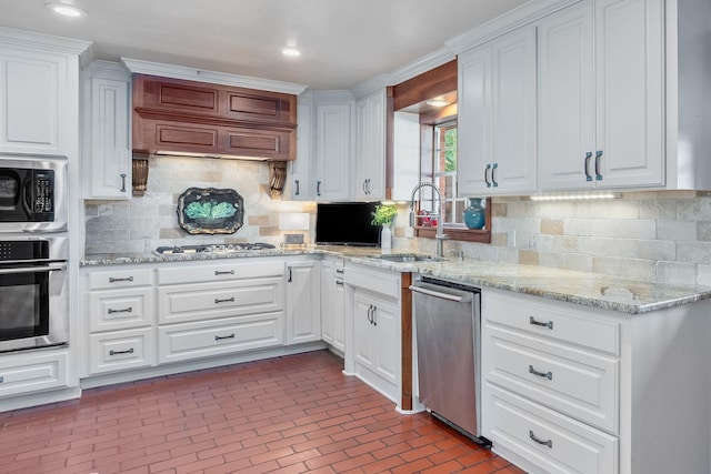 6030 Arden St, Shreveport, LA 71106 - kitchen featuring appliances with stainless steel finishes, white cabinetry, brick patterned floors, tasteful backsplash, and a sink