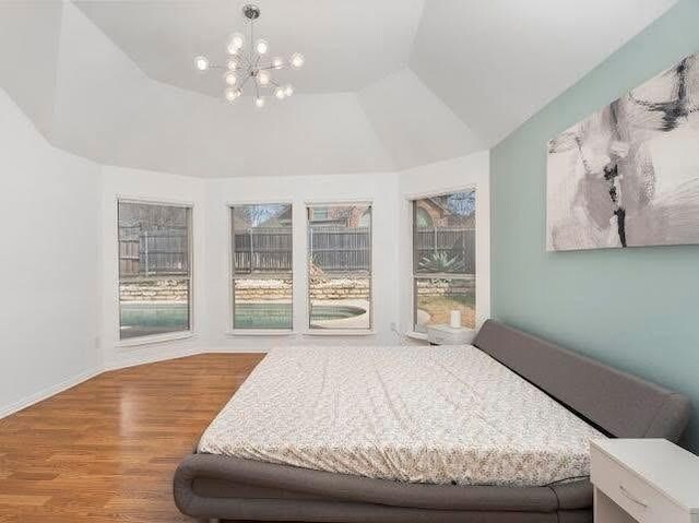 bedroom with wood finished floors and a chandelier