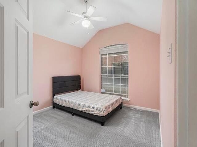 bedroom with carpet, baseboards, lofted ceiling, and a ceiling fan