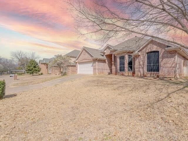 ranch-style home with brick siding and driveway
