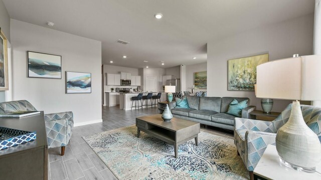 164 Trinity St, Grandview, TX 76050 - living room with baseboards, wood tiled floors, and recessed lighting