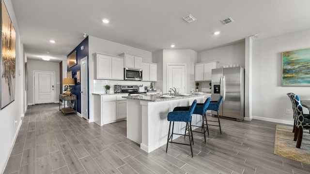 164 Trinity St, Grandview, TX 76050 - kitchen featuring appliances with stainless steel finishes, baseboards, backsplash, white cabinets, and recessed lighting