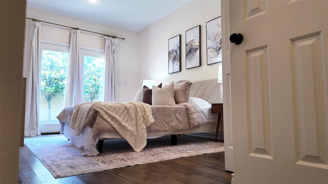 bedroom with multiple windows and dark wood-style flooring