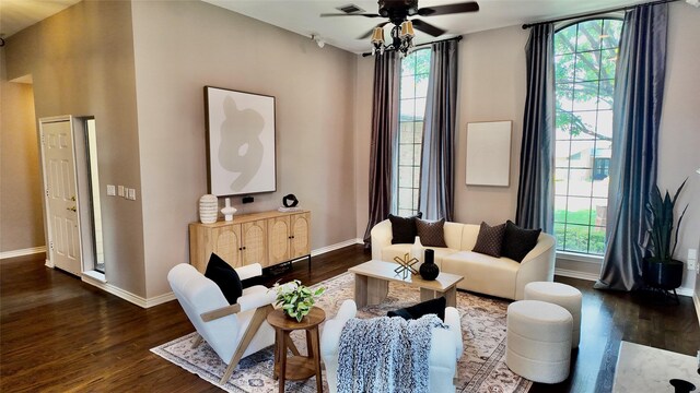 living room with dark wood-type flooring, baseboards, and plenty of natural light