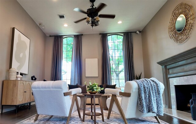 sitting room with ceiling fan, wood finished floors, a high end fireplace, and recessed lighting