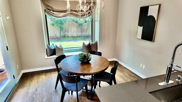 dining space with a chandelier, baseboards, and wood finished floors