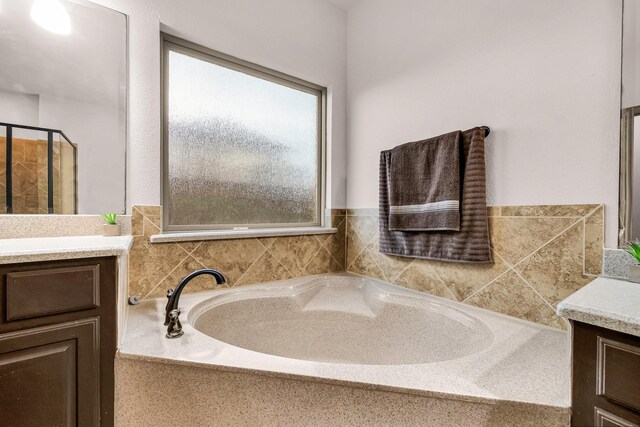 full bathroom with vanity and a garden tub