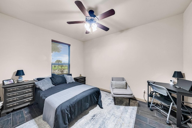 bedroom with an office area, wood finished floors, and ceiling fan