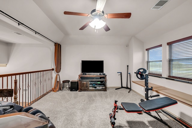 exercise room featuring ceiling fan, carpet flooring, vaulted ceiling, and baseboards