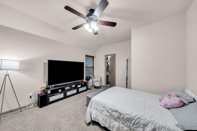 carpeted bedroom with a walk in closet and ceiling fan