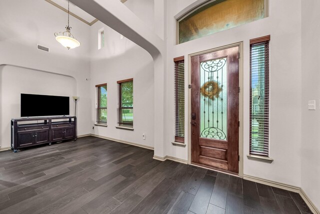 entrance foyer featuring dark wood finished floors, baseboards, and a towering ceiling