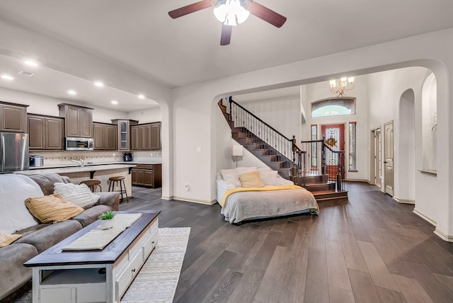 living area with stairs, arched walkways, dark wood-style floors, ceiling fan, and recessed lighting