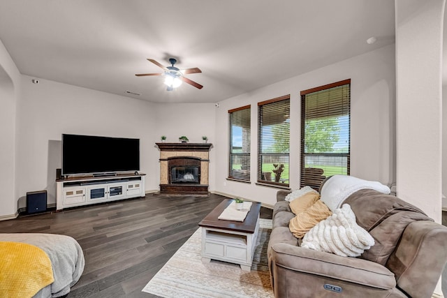 living room with a ceiling fan, wood finished floors, a glass covered fireplace, and baseboards