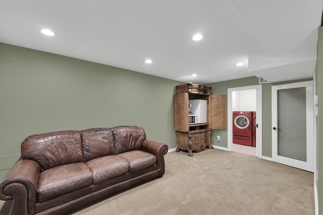 living room with washer / dryer, recessed lighting, light carpet, and baseboards