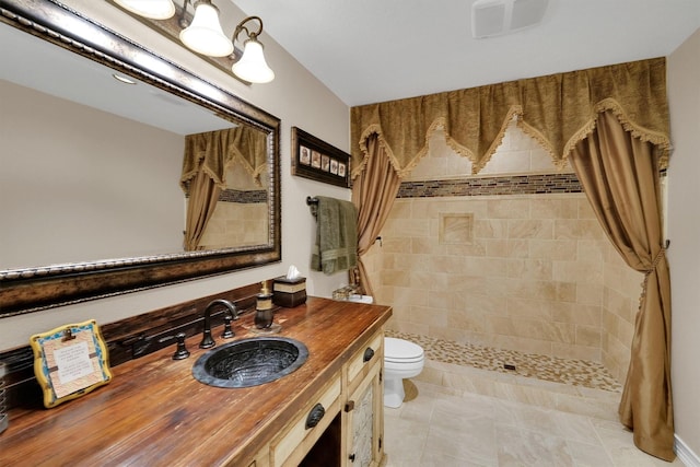 full bathroom featuring a shower stall, toilet, and vanity