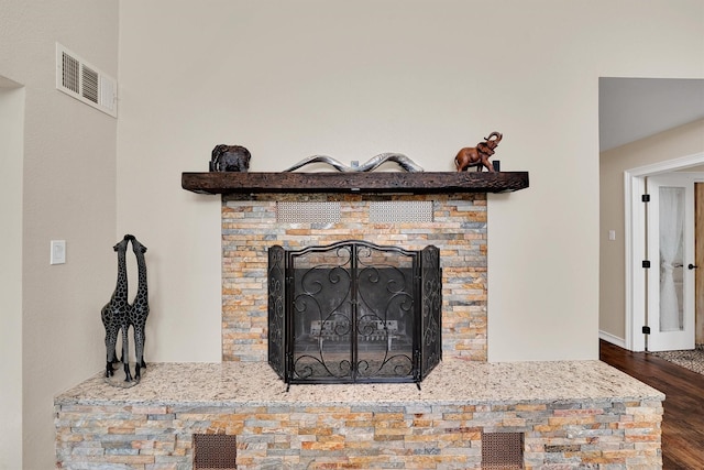 detailed view of wood finished floors, baseboards, and a fireplace