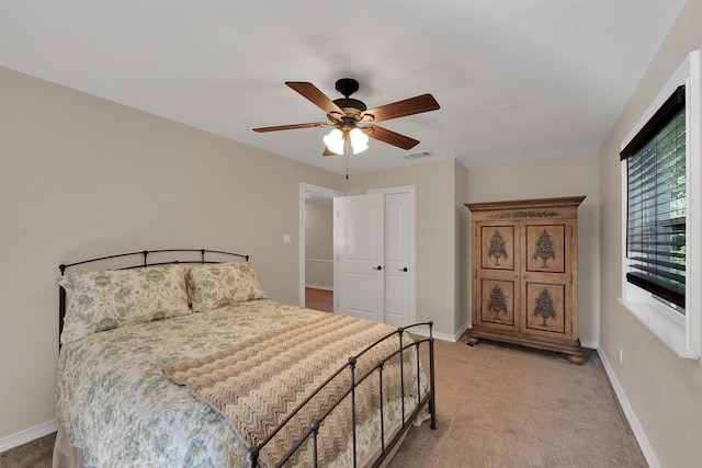 bedroom featuring light carpet, baseboards, ceiling fan, and a closet