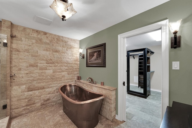 bathroom featuring a tile shower and a freestanding bath