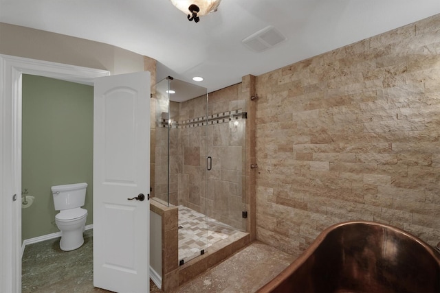 full bathroom featuring a stall shower, a freestanding bath, toilet, and baseboards