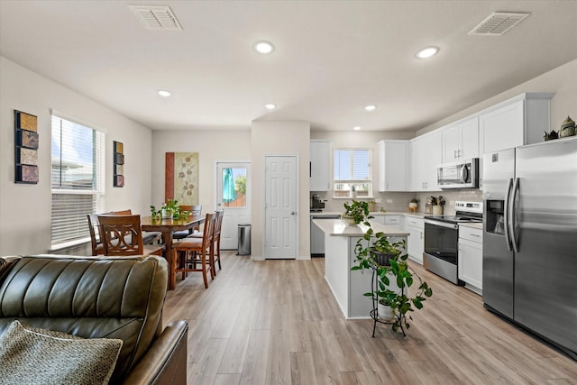 1145 Vernon Dr, Aubrey, TX 76227 - kitchen featuring stainless steel appliances, a center island, open floor plan, light countertops, and white cabinets