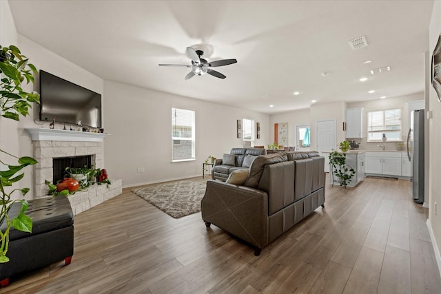 1145 Vernon Dr, Aubrey, TX 76227 - living room with a ceiling fan, light wood-style flooring, recessed lighting, a fireplace, and baseboards