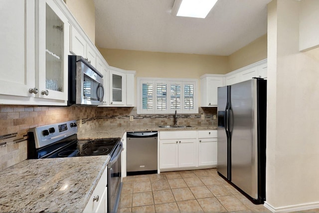 kitchen with stainless steel appliances, a sink, and white cabinets