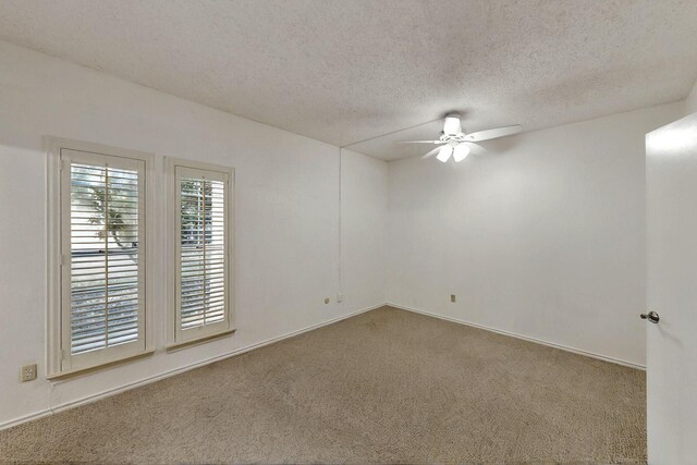 empty room featuring a ceiling fan, carpet, a textured ceiling, and baseboards