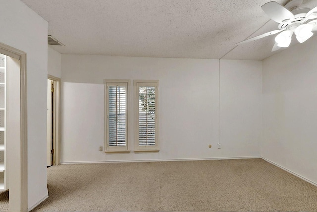 empty room featuring carpet flooring, a textured ceiling, ceiling fan, and baseboards