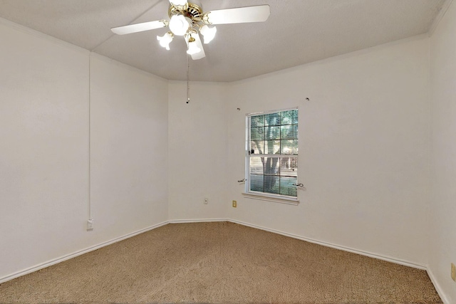 carpeted empty room featuring ceiling fan, crown molding, and baseboards