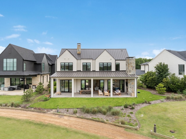 13736 Waterside Dr, Malakoff, TX 75148 - rear view of house with a chimney, a patio, a yard, a standing seam roof, and metal roof