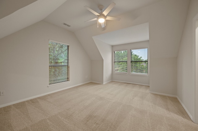 additional living space featuring light carpet, vaulted ceiling, a ceiling fan, and baseboards