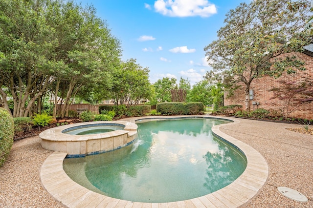 view of pool with a pool with connected hot tub and fence
