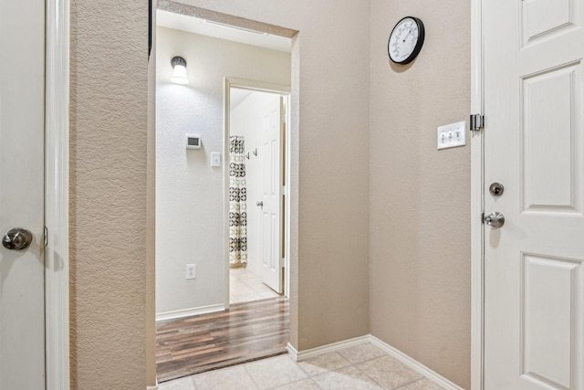 8833 Stirrup Way, Fort Worth, TX 76244 - doorway with tile patterned floors, a textured wall, and baseboards