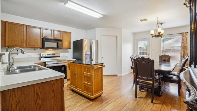 12712 Feathering Dr, Frisco, TX 75036 - kitchen featuring stainless steel appliances, a sink, a chandelier, a kitchen island, and brown cabinetry